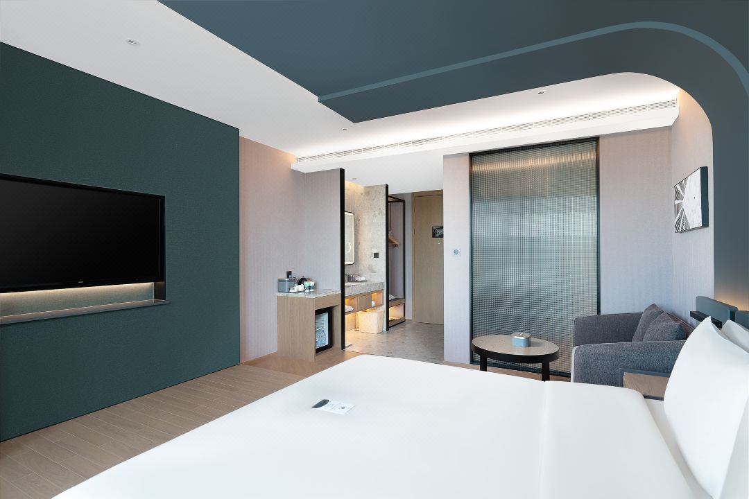 Contemporary hotel room featuring a spacious layout with a bed, seating area, and modern amenities.