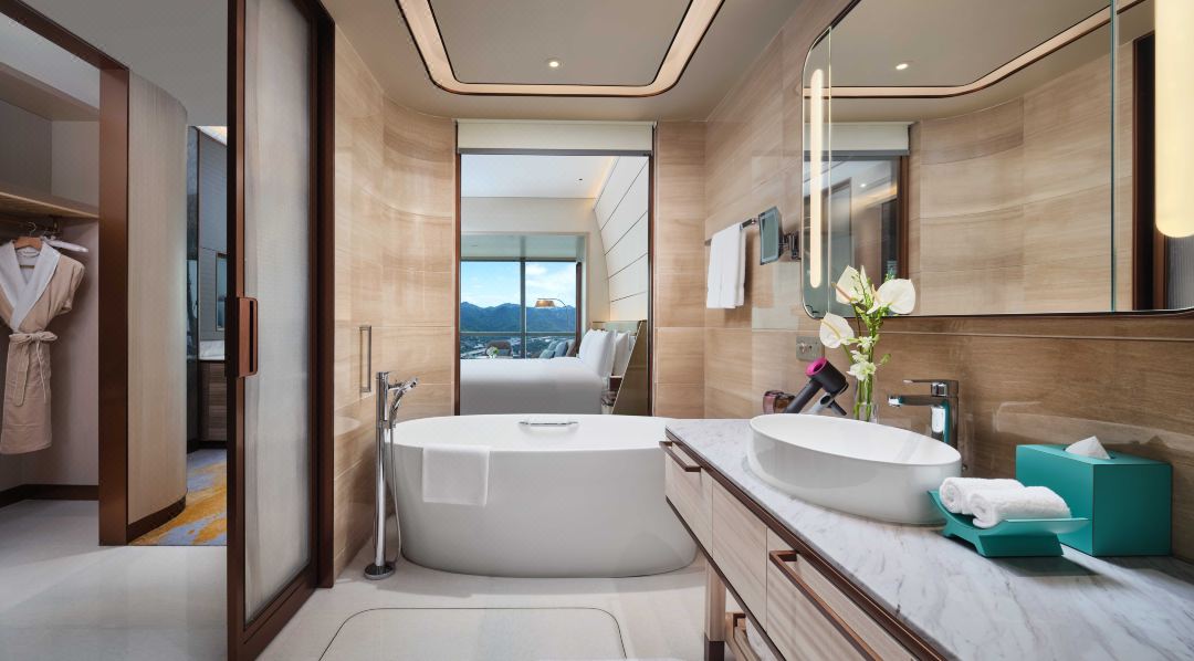 Luxurious hotel bathroom with a freestanding tub and modern decor, featuring scenic mountain views.