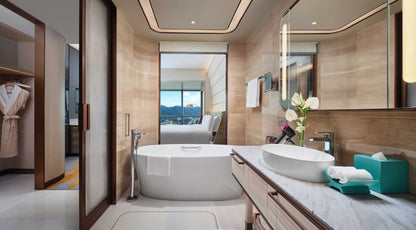 Luxurious hotel bathroom with a freestanding tub and modern decor, featuring scenic mountain views.