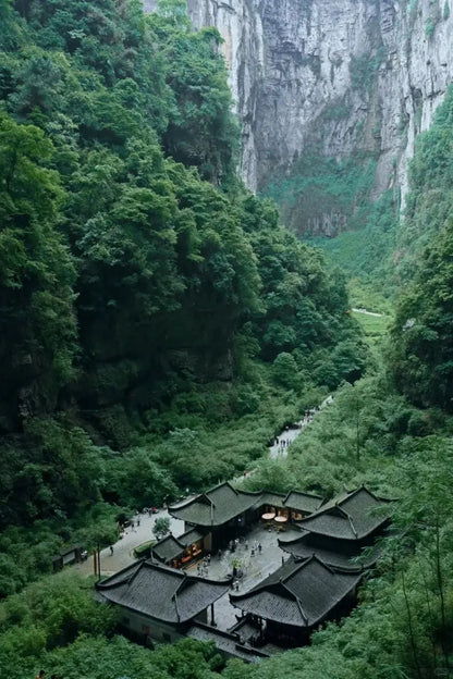 Stunning view of the Longshuixia Gorge with lush greenery and traditional architecture in Chongqing, China.